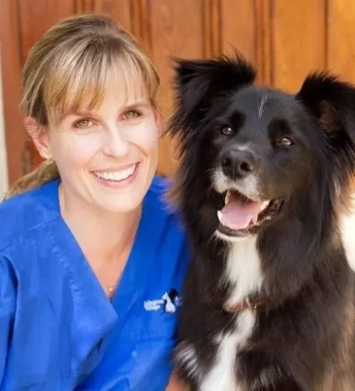 Dr. Erin Spence Examining a Small Black Dog